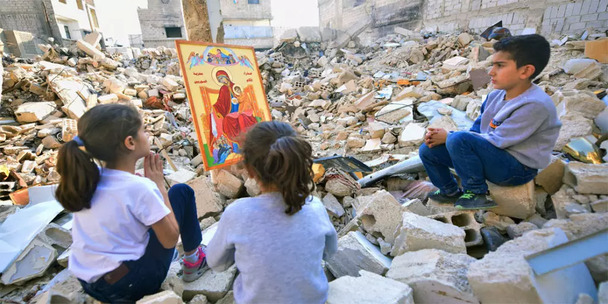 Kinder in Syrien beten in der Ruine ihrer zerstörten Kirche vor einer Ikone der Gottesmutter - Die Päpstliche Stiftung _Kirche in Not_ hilft der Kirche in mehr als 130 Ländern, vor allem dort, wo sie verfolgt oder bedrängt ist.